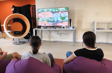 Groupe d'enfants assis sur un canapé et jouant à la console