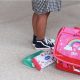 Photo d'un sac à dos d'école au pied d'un enfant