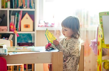 petite fille découpant une feuille avec une paire de ciseaux