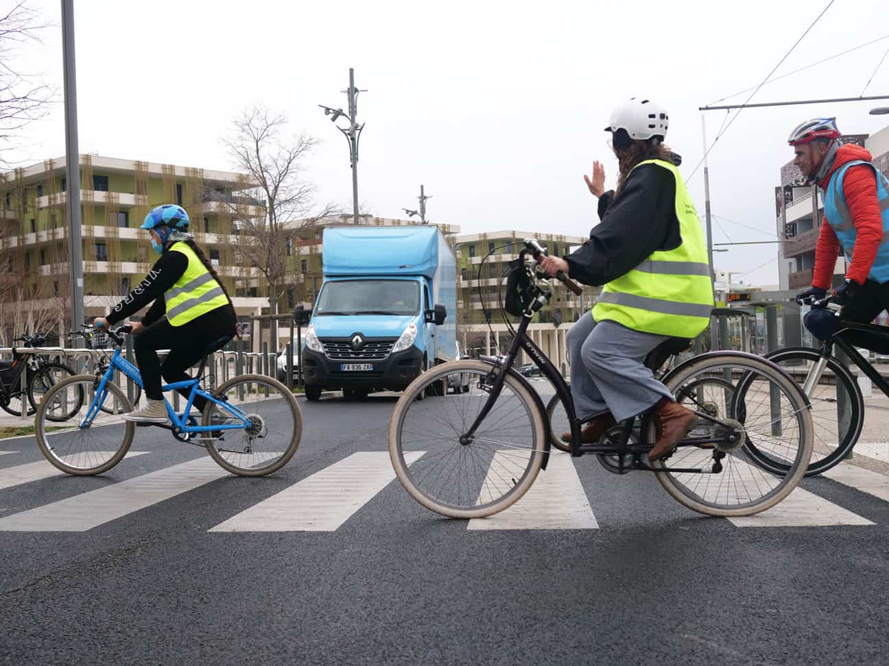 Cyclistes passant sur un passage piéton et remerciant une voiture qui s'arrête