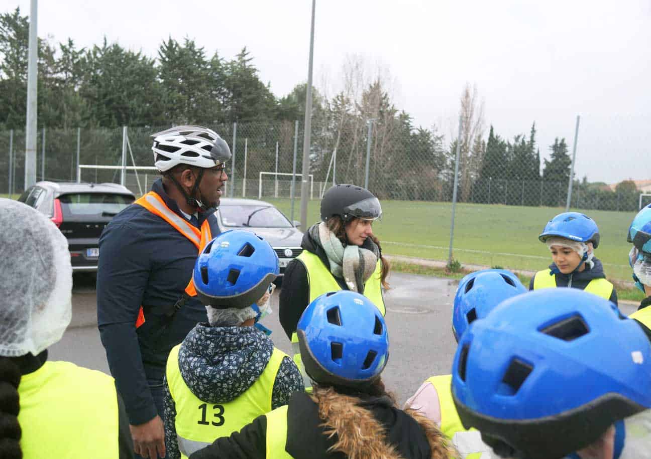 Groupe de personnes avec des gilets jaune et des casques de vélo bleu