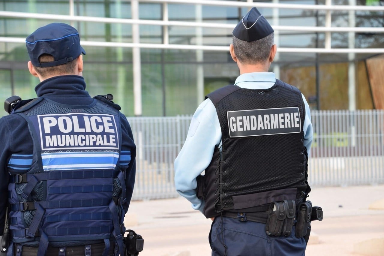 Un policier municipal et un gendarme se tenant debout de dos